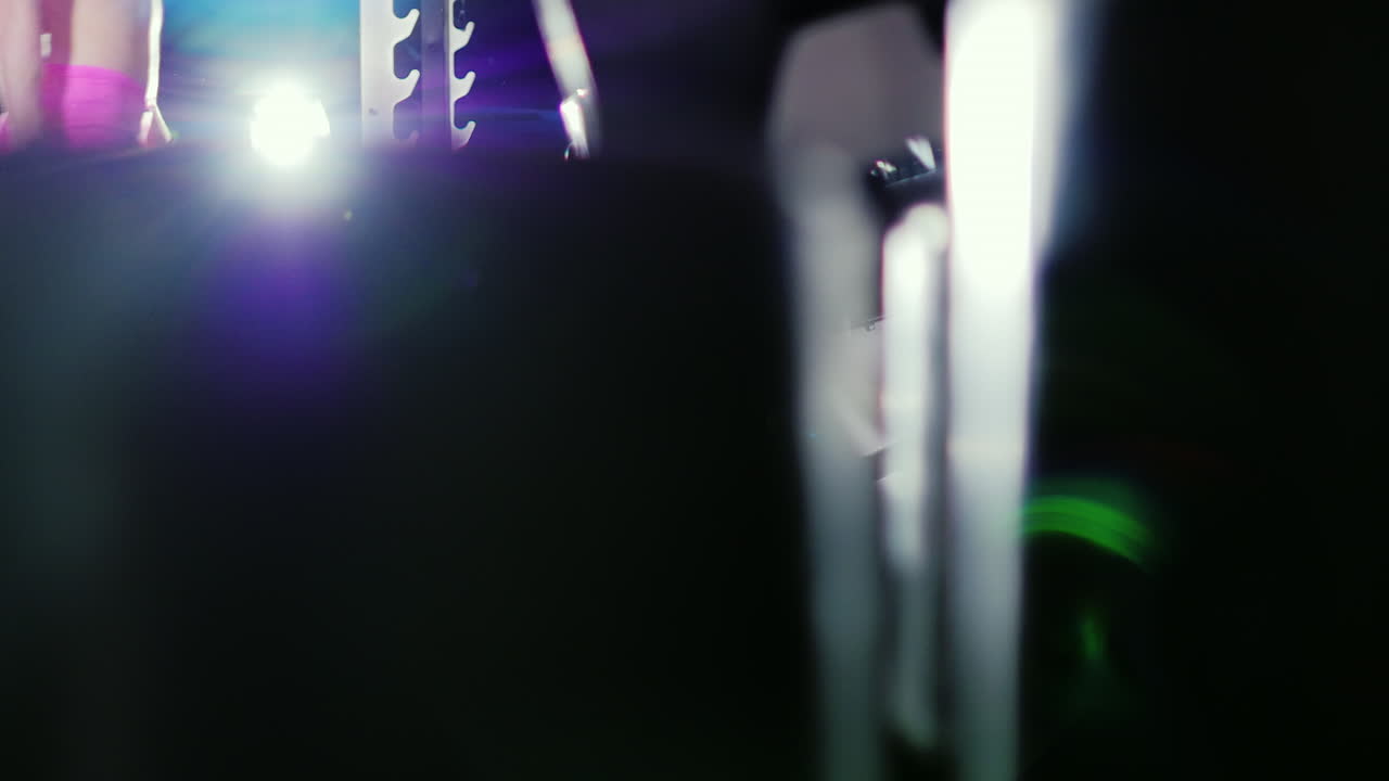 운동 선수는 스포트라이트 슬로우 모션 프로레에서 아령으로 등 근육 훈련을 시작합니다.