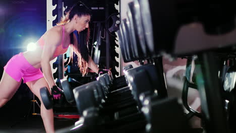 Athletic-Woman-Starts-Training-Trains-Back-Muscles-With-Dumbbells-In-The-Spotlight-Slow-Motion-Prore