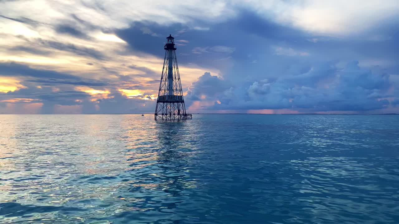 clip panorámico de un faro en un arrecife de cocodrilos sobre el océano en los cayos de florida, ee.uu.
