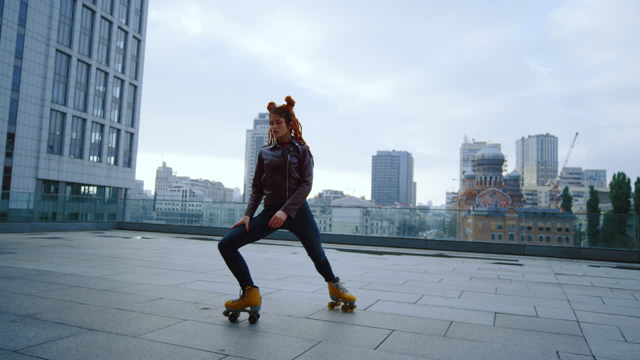 Femme rousse sportive réalisant des figures de roller en milieu urbain.