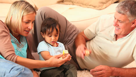 doting parents playing with their little child on carpet