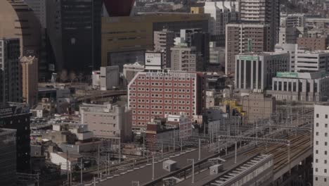 wide of japanese cityscape, kokura, kitakyushu, japan with shinkanzen bullet train and mountains