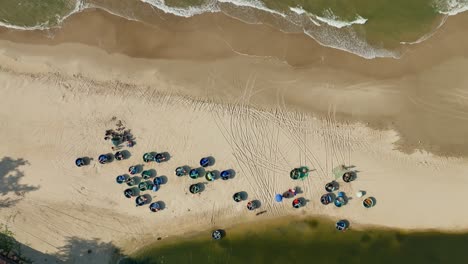 Drone-view-basket-boats-nailing-on-sand-of-Ke-Ga-beach,-Phan-Thiet-Binh-Thuan-province,-central-Vietnam