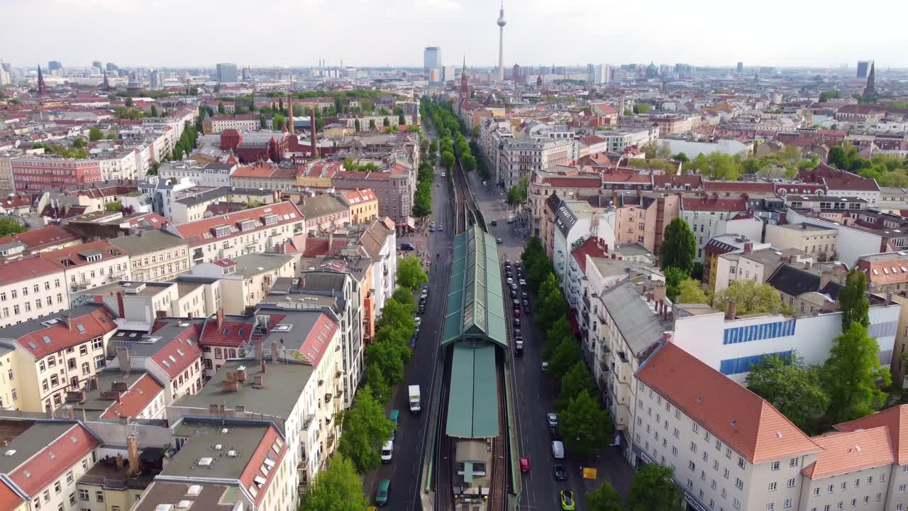Vidunderlig droneoptagelse med langsomt tilt ned, der starter ved tv-tårnet og slutter ved en forhøjet S-bane, der kommer ind i billedet, af Berlin Prenzlauer Berg, Schönauer Allee, Forår 2022