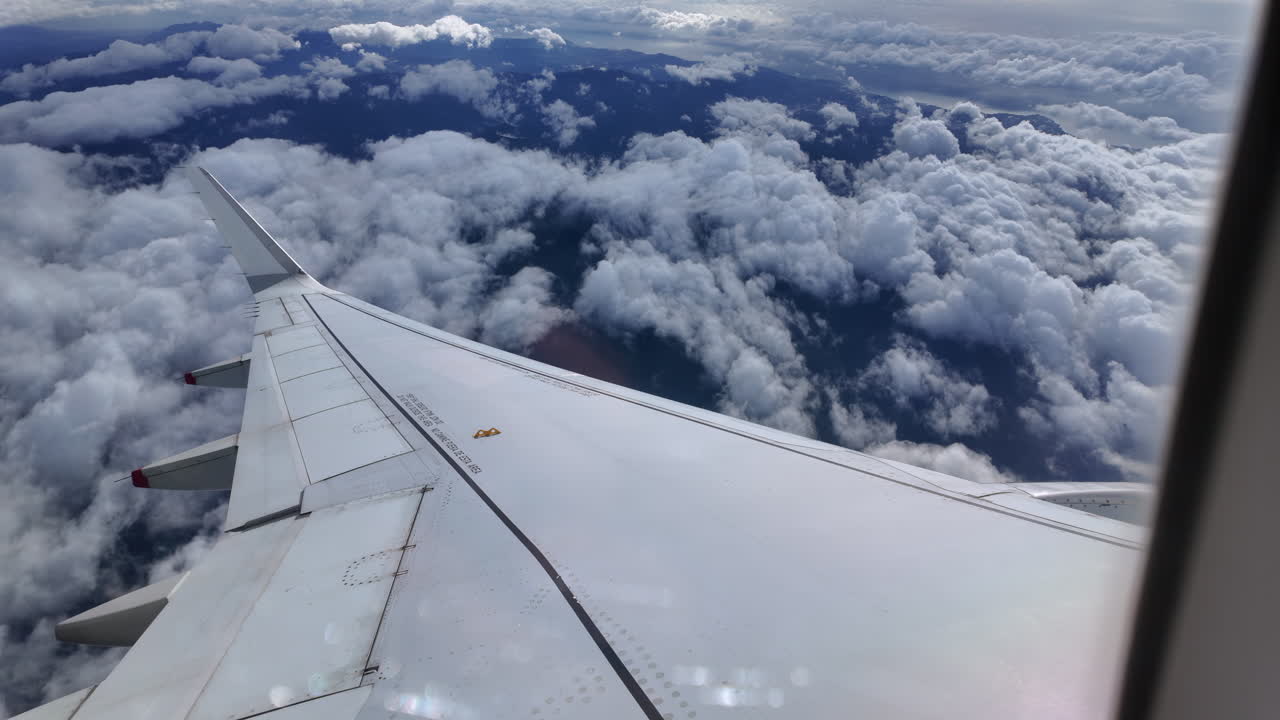 View from an airplane window of the aircraft wing in the clouds