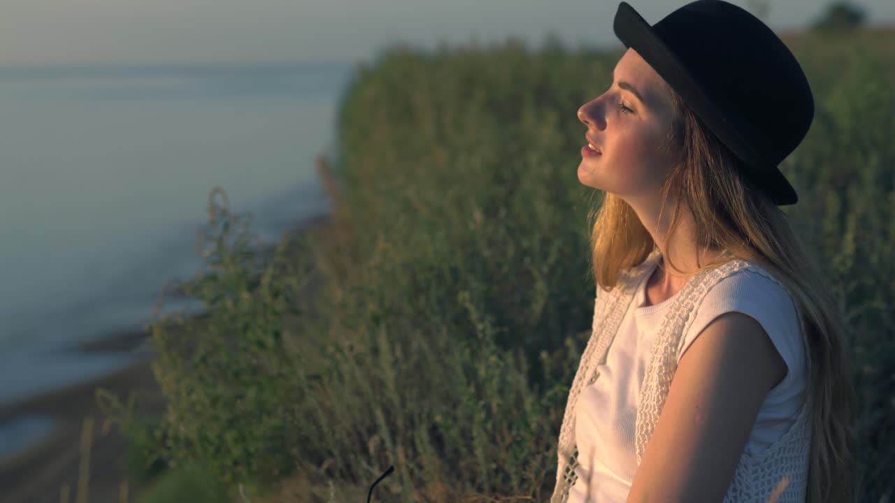 mujer mirando la puesta de sol en la playa