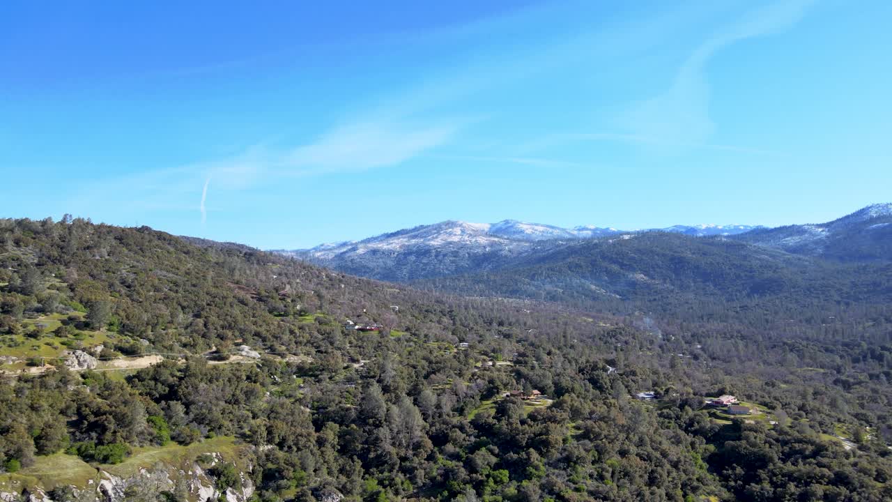 vista aérea del parque nacional de yosemite, bosques verdes, colinas onduladas, montañas cubiertas de nieve, cielo azul claro, paisaje pintoresco, la tranquilidad de la naturaleza, estados unidos