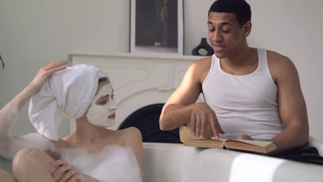 interacial couple enjoy a relaxing bath and a book