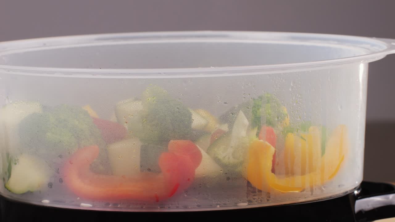 Mixed vegetables, carrots, broccoli, and cauliflower in a food double boiler steamer basket in a stainless steel pot, healthy diet cooking method preserving minerals, vitamins and flavor