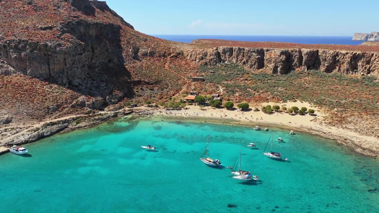 Vista aerea con drone della cala di ancoraggio turchese e della spiaggia sabbiosa sotto l'altopiano roccioso dell'isola di Gramvousa, Gramvousa, Grecia