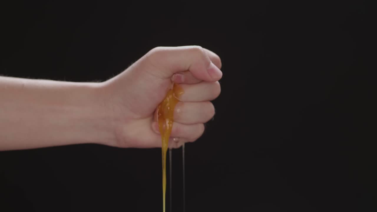 Squeeze The Chicken Egg Peeling On A Black Background