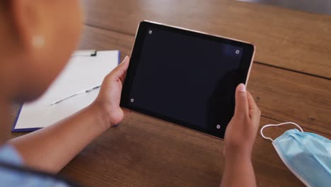 African-american-female-doctor-having-video-call-consultation-using-tablet-with-copy-space