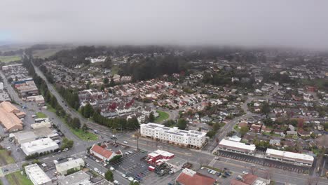 High aerial panning shot of the mountains around Santa Cruz blanked by thick fog on the coast of Northern California. 4K