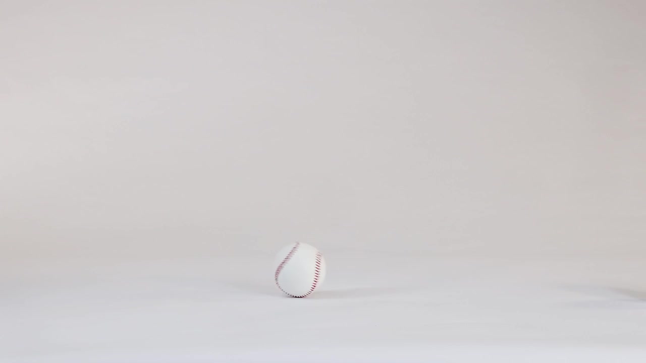 Baseball Rolling Across a Clean White Studio Background