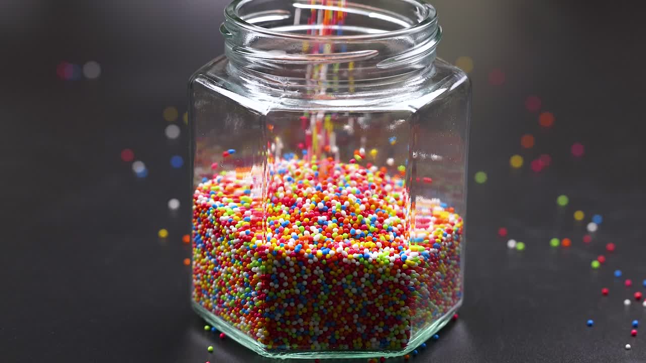 las salpicaduras coloridas se vierte en un frasco de vidrio