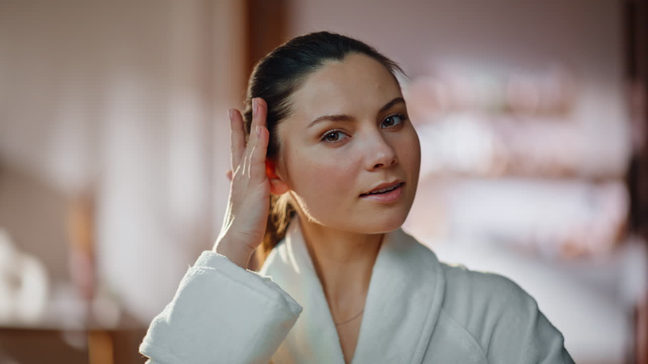 Young woman enjoying mirror reflection touching perfect healthy skin closeup
