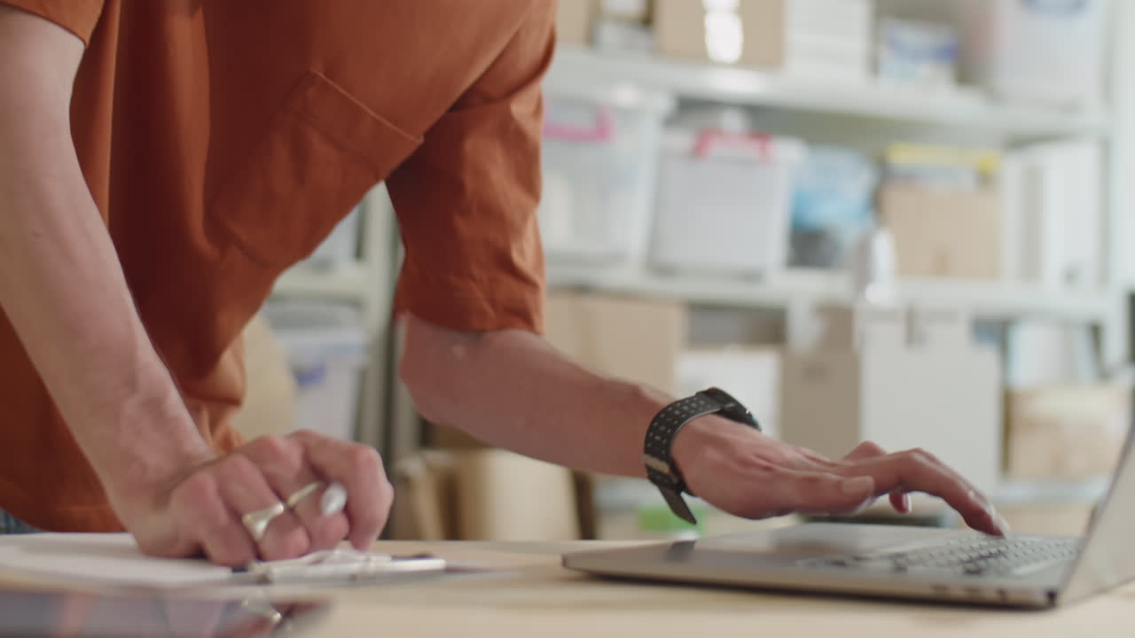 Delivery Service Manager Working on Laptop and Making Notes