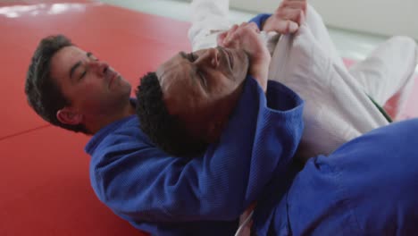 judoka strangling his opponent on the judo mat