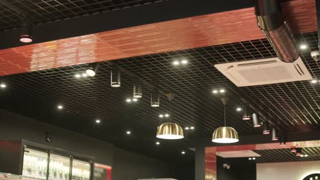 modern ceiling featuring grid patterns, recessed lighting, pendant lamps, and a ventilation system. sleek, contemporary design in a retail or commercial space