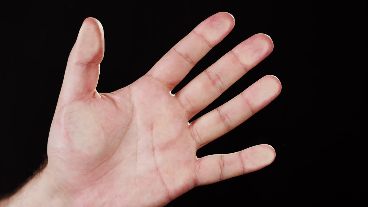 Primo piano di una mano che si chiude lentamente a pugno
