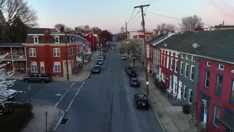 ascend drone shot de cidade americana com casas coloridas durante o pôr do sol à noite, eua