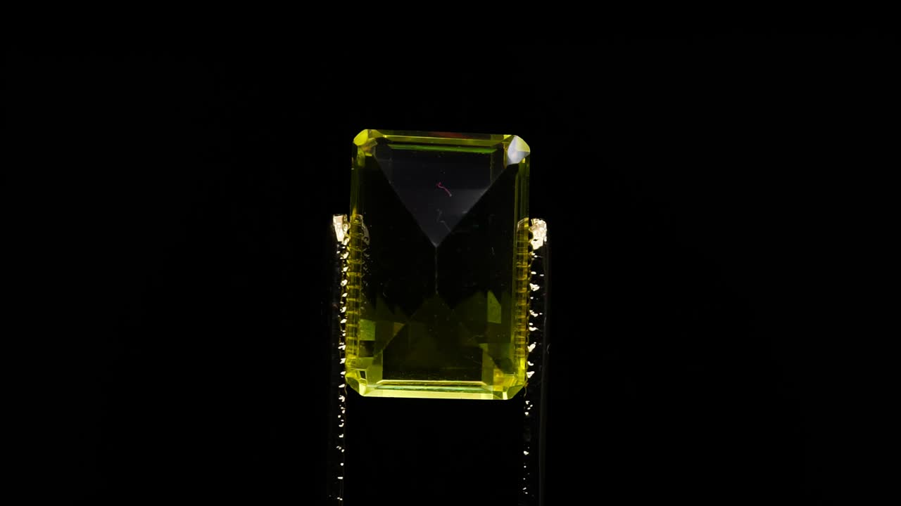 자연 황색 시트린은 회전 테이블에 있는 핀세저에 있습니다.