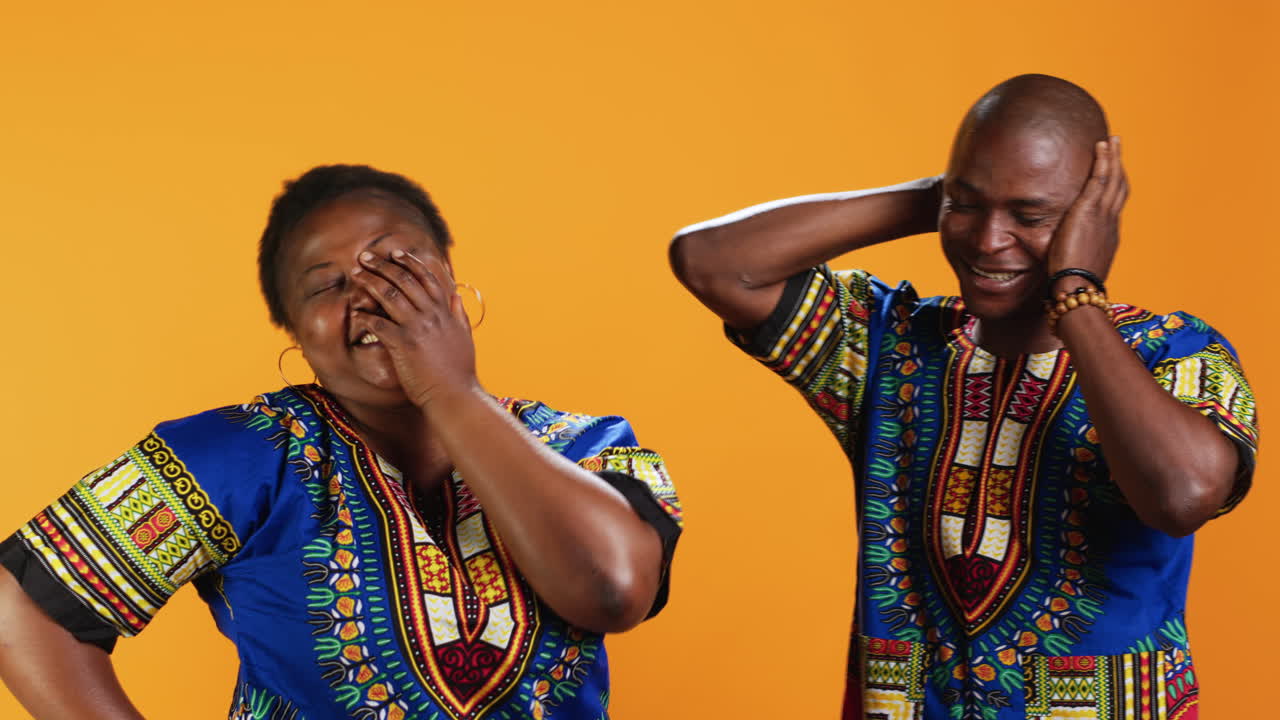 Una alegre pareja afroamericana riéndose de algo en el estudio.