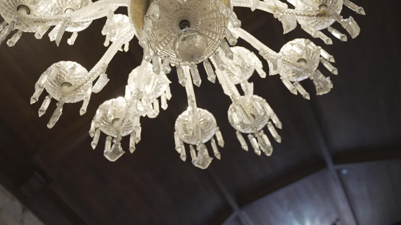 Primo piano di un lampadario di vetro con più luci sul soffitto.