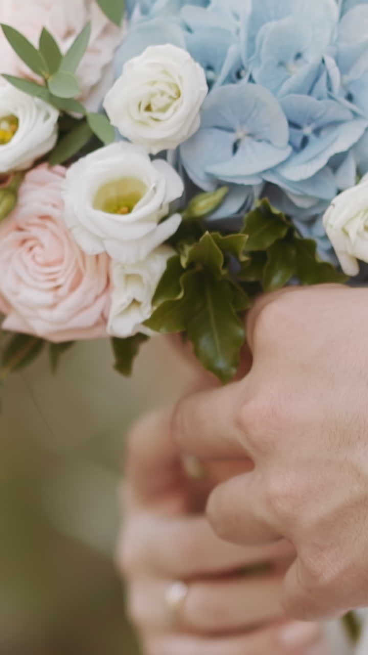 Careful man in jacket embraces wife holding gentle flowers bouquet at wedding ceremony closeup slow motion. Young couple loving relationship