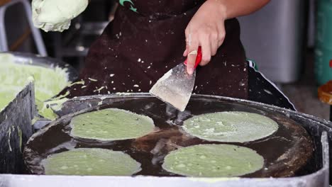 preparing and cooking green crepes on hot griddle