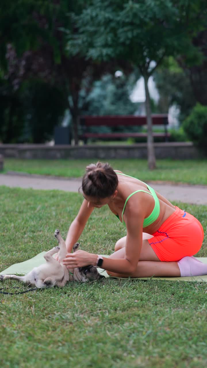 mujer haciendo ejercicio con un pug en el parque