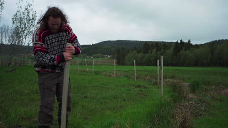 Caucasian-Man-Is-Pulling-Out-Of-The-Ground-Wooden-Post