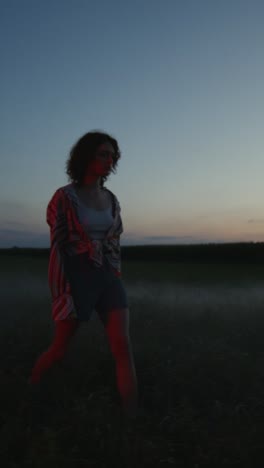 woman walking in a field at sunset