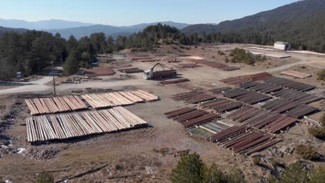 Vista-Aérea-Del-Agarrador-De-Troncos-Entre-El-Día-Del-Aserradero-De-Camiones-De-Carga-De-Madera