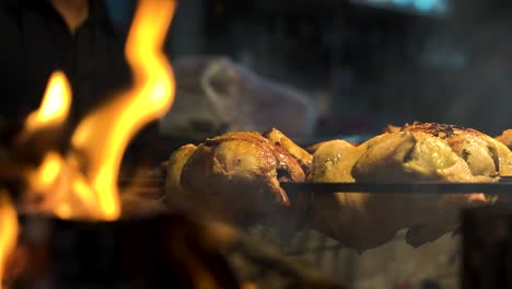 Primer-Plano-De-La-Parrilla-De-Pollo-En-La-Quema-De-Carbón-Muy-Caliente-En-Una-Parrilla-En-Cámara-Lenta-Y-Llamas