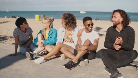 descansando jóvenes amigos en la costa de la ciudad