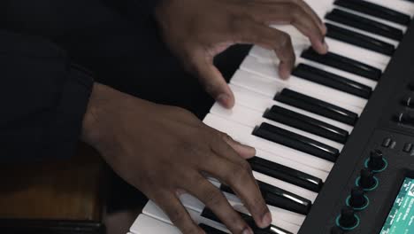 primer plano de manos tocando teclas de piano, mostrando detalles de la actuación musical