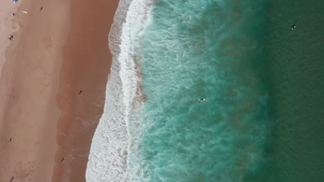 Beach-with-crashing-waves-drone-panning-shot