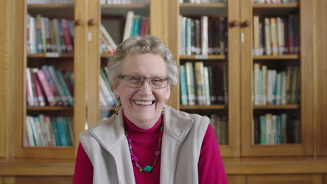portrait of happy elderly caucasian woman in library laughing cheerful enjoying relaxed retirement wearing pink jersey