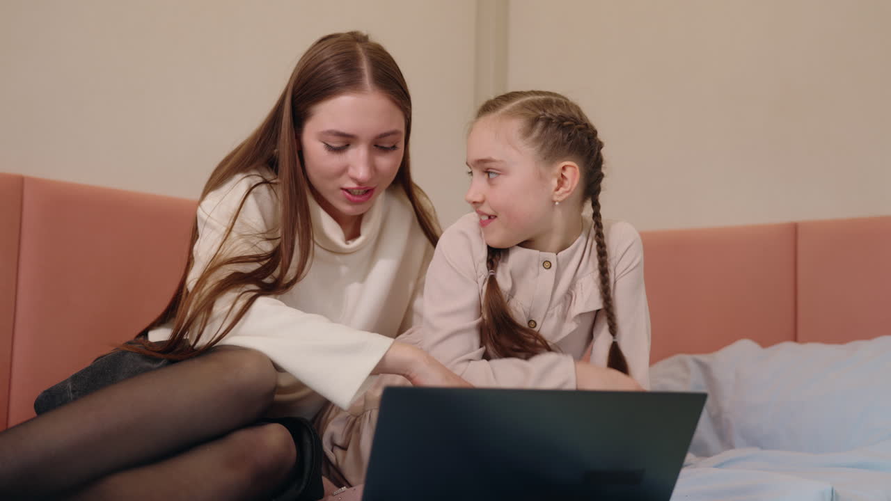 어머니와 딸이 함께 노트북을 사용하고 있습니다.