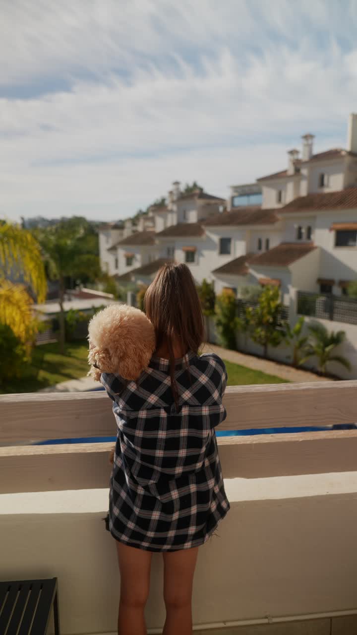 Ragazza e cane sul balcone con vista