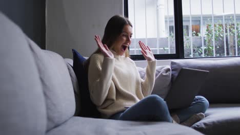 woman having a video chat on her laptop at home