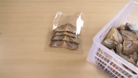 imágenes de primer plano del embalaje de pescado en la bolsa de plástico en el proceso de embalaje