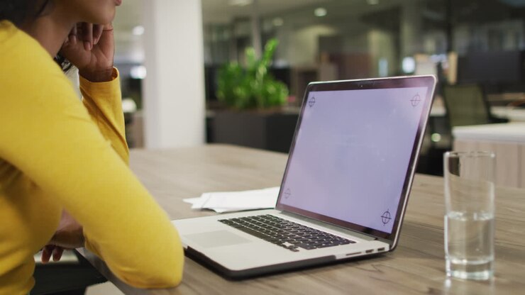 Video einer birassischen Frau, die einen Laptop mit Platz für Text auf dem Bildschirm nutzt.