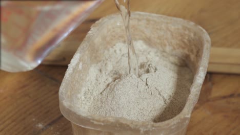 Pouring-Water-To-A-Container-With-Flour---close-up-slowmo