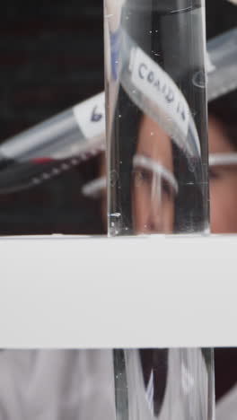 woman doctor checks patient blood sample and puts tube into rack cell at covid test slow motion. probe lens footage of illness research macro view