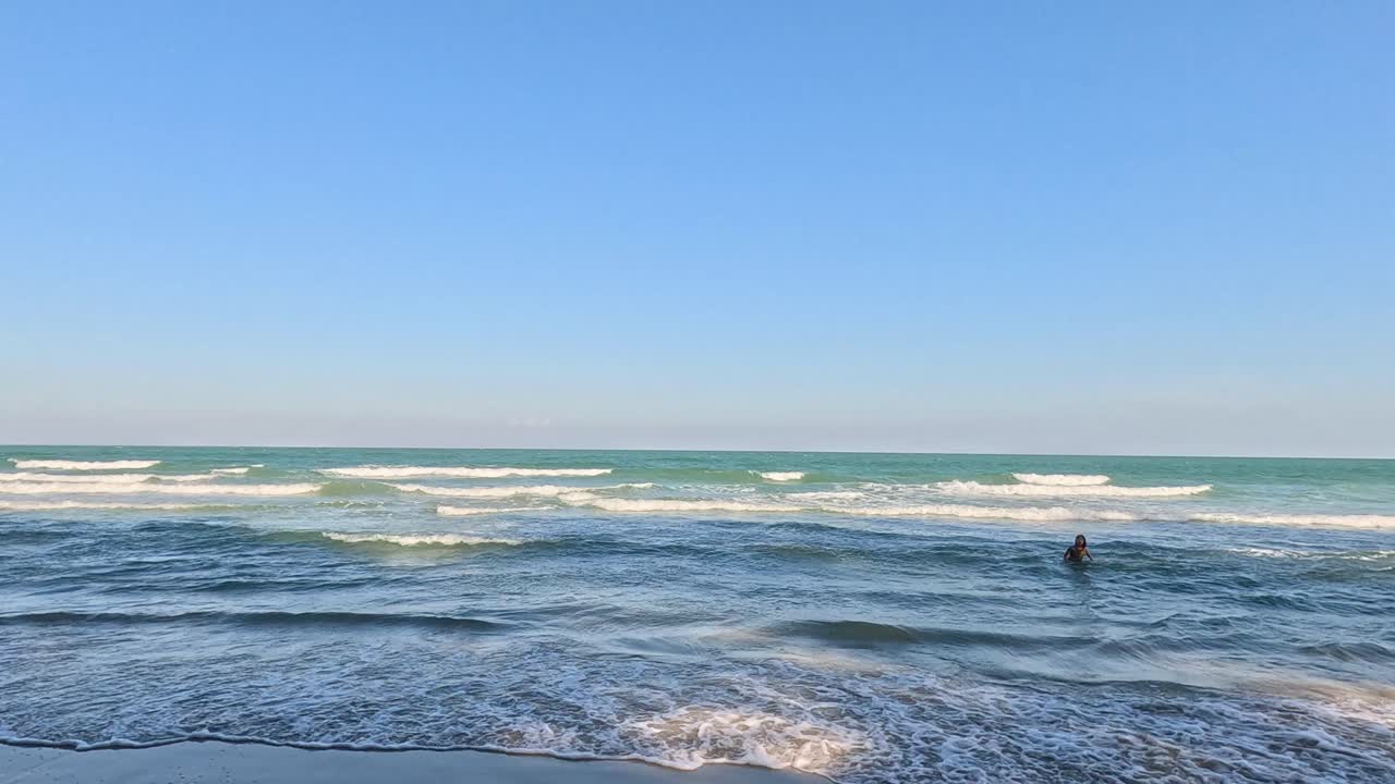 이 많은 해변 에서 파도 를 즐기는 서퍼 들