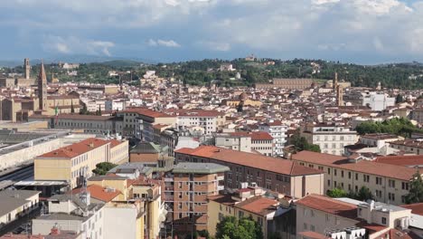 aerial rising over florence, italy, horizon of terracotta rooftops and green hills