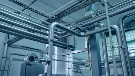complicated system of pipes interweaving with each other. stainless steel tubes at the modern technological plant for producing dairy.
