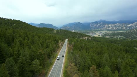 traffic on the paved road over wooded mountains near estes park town in northern colorado, usa